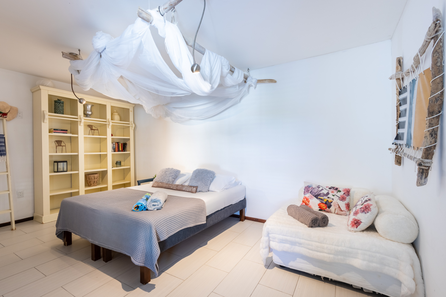 Lichte slaapkamer met klamboe en zithoek
